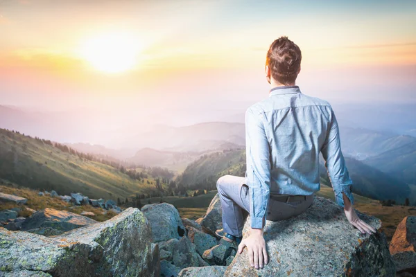 Businessman at the top of the mountain sitting and thinking — Stock Photo, Image