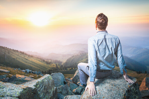 businessman at the top of the mountain sitting and thinking