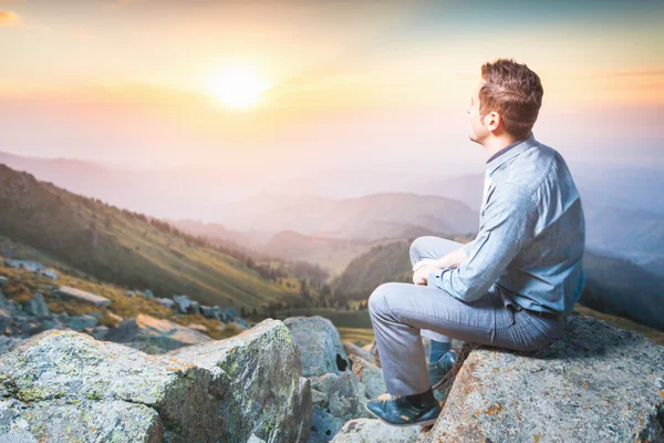 Hombre de negocios en la cima de la montaña sentado y pensando — Foto de Stock