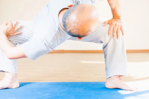 Inspirado asiático hombre haciendo ejercicio de yoga indoor —  Fotos de Stock