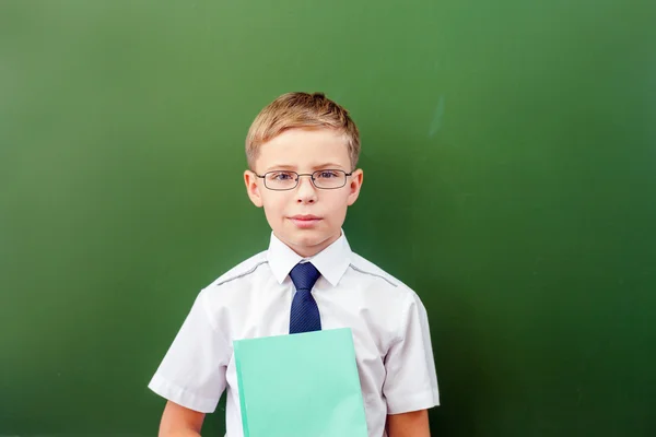 Écolier réussi debout près du tableau noir dans la classe de l'école — Photo