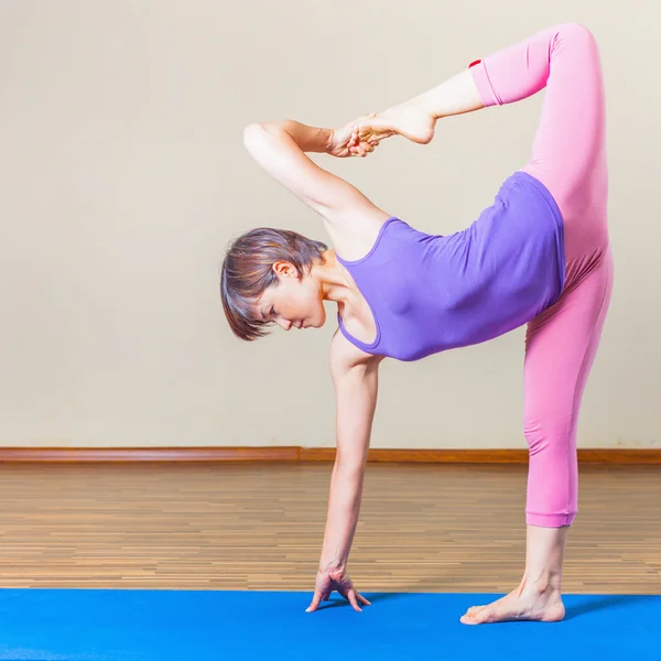 Mature asian woman doing exercise of yoga indoor