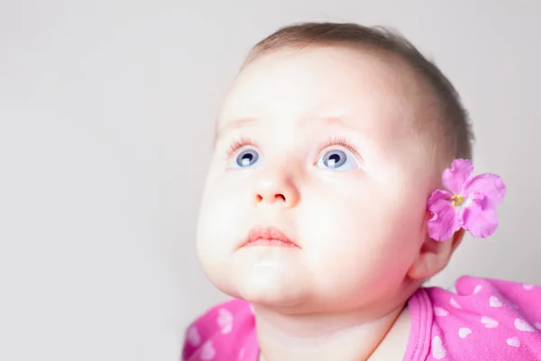 Portrait of a baby girl with blue eyes looking up — Stock Photo, Image