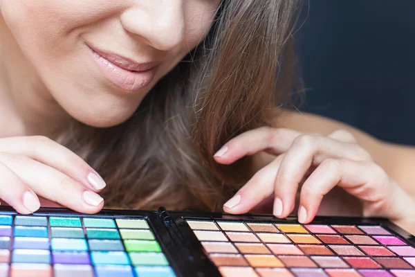 Mooie vrouw met kleurrijke palet voor fashion make-up — Stockfoto
