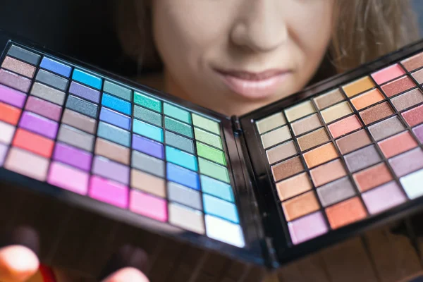 Mooie vrouw met kleurrijke palet voor fashion make-up — Stockfoto