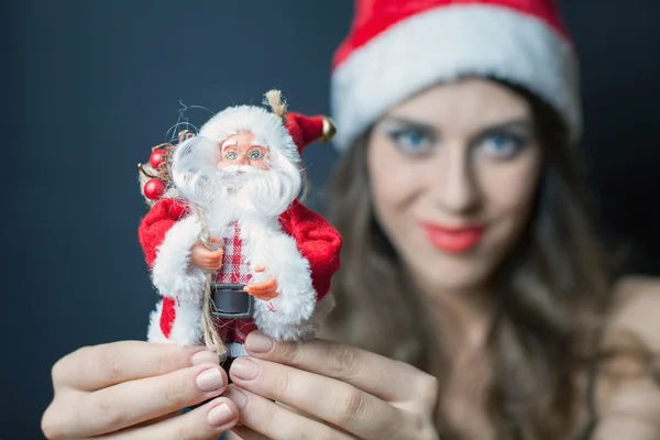 Mulher sexy vestida com roupas de Papai Noel dá-lhe brinquedo — Fotografia de Stock