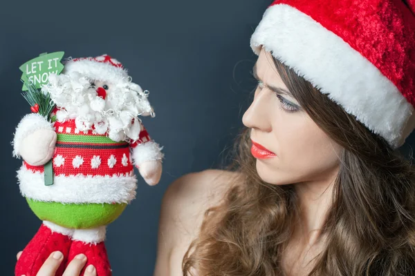 Descontente carrancudo vestido de chapéu vermelho olhando para Papai Noel — Fotografia de Stock