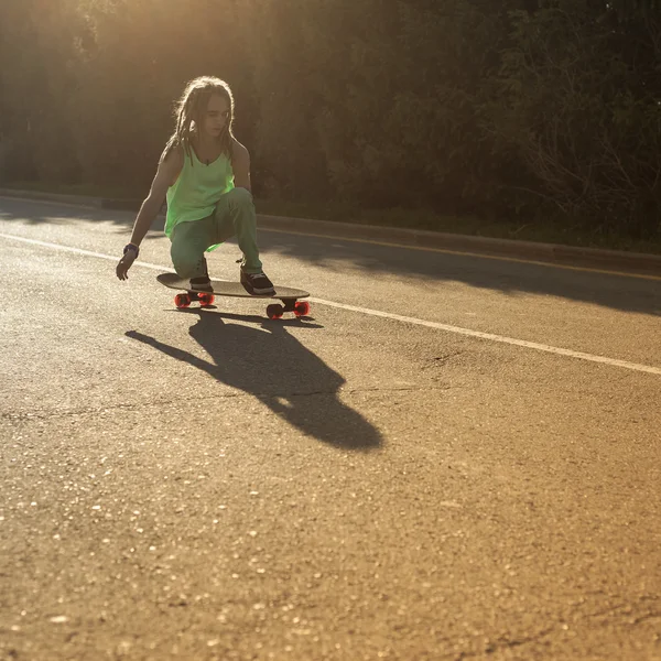 Подросток катается на скейтборде по дороге — стоковое фото