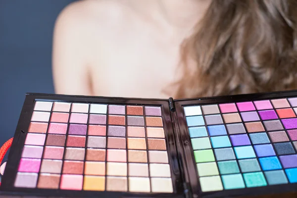 Mooie vrouw met kleurrijke palet voor fashion make-up — Stockfoto