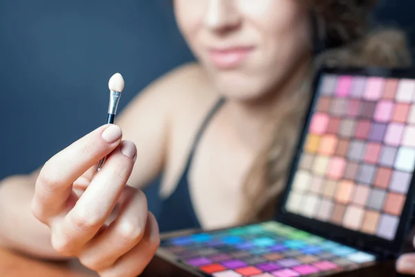 Schöne kaukasische Frau macht Make-up — Stockfoto