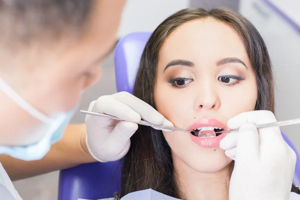Tandläkare läkare behandlar tänder tålmodiga tjej i tandläkarens — Stockfoto