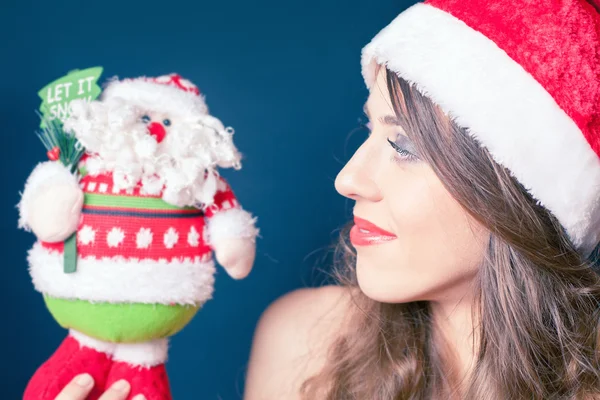 Mulher bonita feliz segurando um brinquedo de Papai Noel — Fotografia de Stock