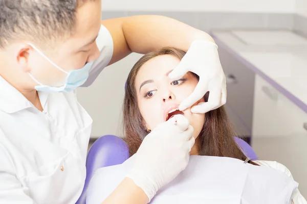 Médico dentista trata dentes paciente menina no consultório odontológico — Fotografia de Stock