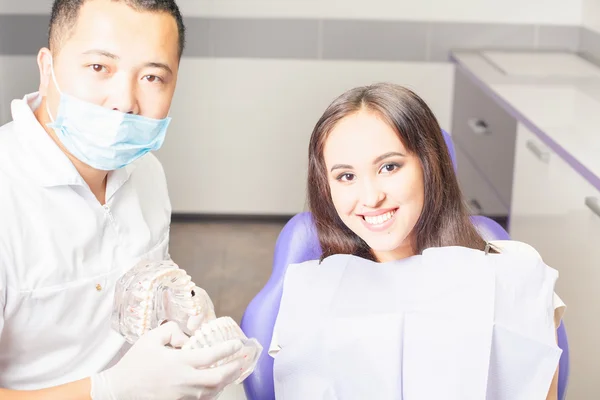 Médico dentista muestra la mandíbula del paciente con dientes — Foto de Stock