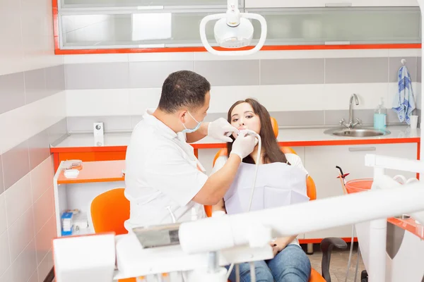 Dentista medico tratta denti paziente ragazza in studio dentistico — Foto Stock