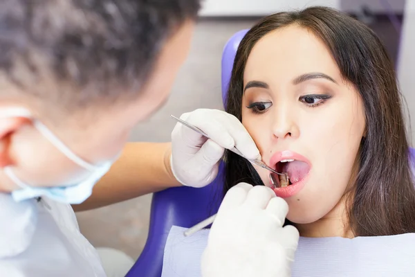 Dentista médico trata dientes paciente chica en el consultorio dental — Foto de Stock