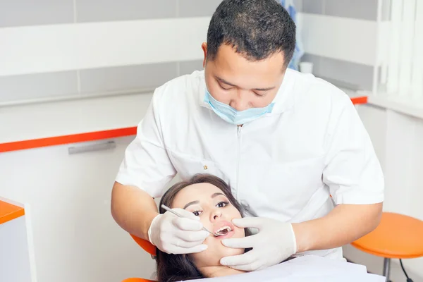 Dentista médico trata dientes paciente chica en el consultorio dental — Foto de Stock