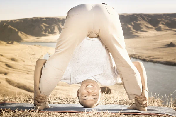 Man doing exercise of yoga outdoor above river valley — Stock Photo, Image