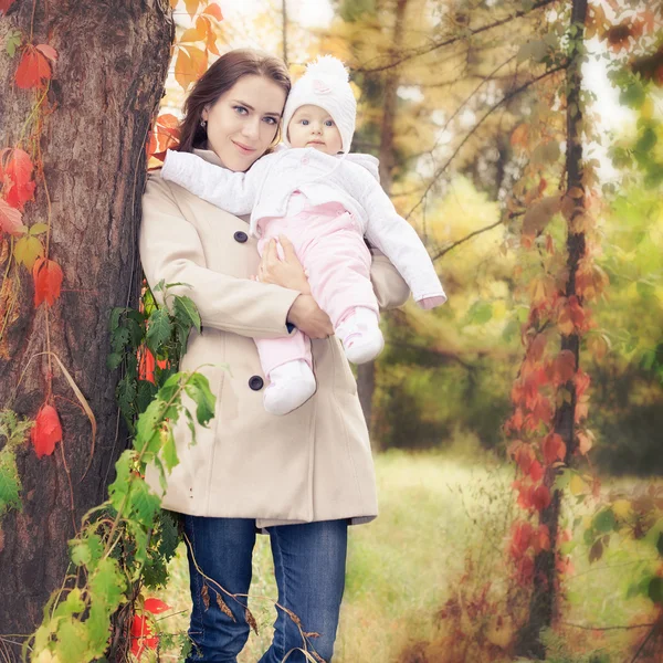 Moda madre a piedi con il suo bambino all'aperto al parco autunnale — Foto Stock