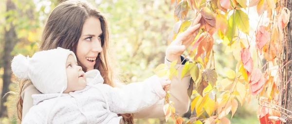 Bonita madre con su bebé al aire libre en el parque de otoño —  Fotos de Stock