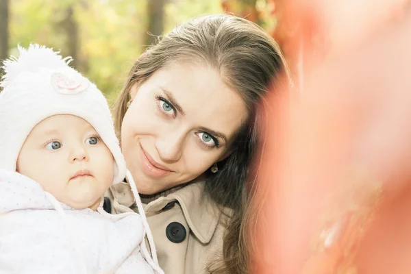 Красива мати зі своєю дитиною на відкритому повітрі в осінньому парку — стокове фото