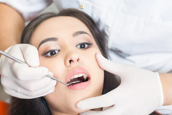 Dentist doctor treats teeth patient girl in dental office — Stock Photo, Image