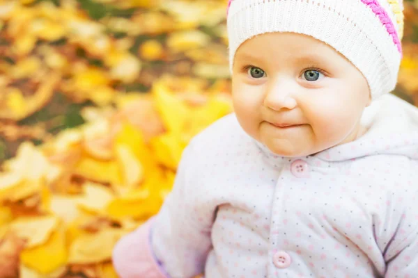 Portrait of baby at autumn park with yellow leaves background — Stock Photo, Image