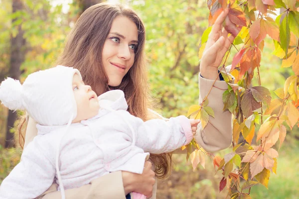 Mãe bonita com seu bebê ao ar livre no parque de outono — Fotografia de Stock