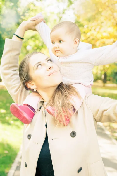 Vackra mamma med hennes baby flicka utomhus på hösten park — Stockfoto