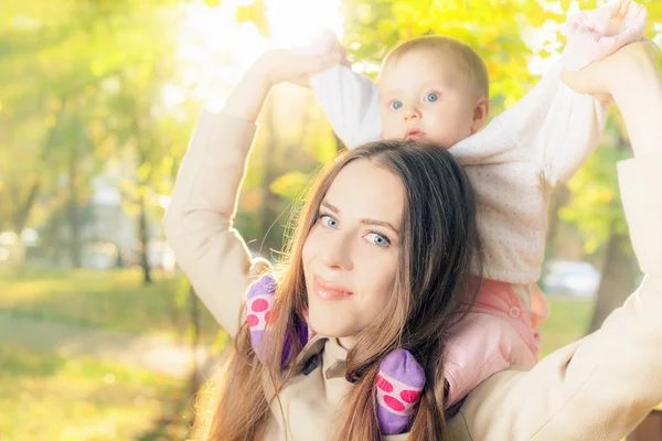 Vackra mamma med hennes baby flicka utomhus på hösten park — Stockfoto