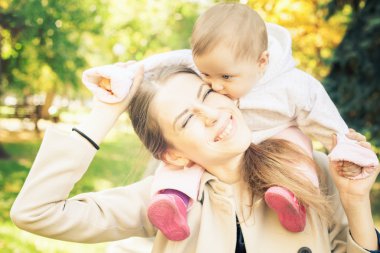 Funny family - mother with her baby outdoor at autumn park
