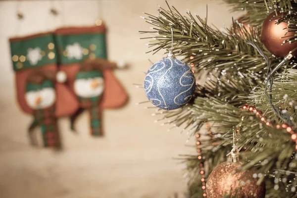Decorated ball on Christmas tree with wooden background — Stock fotografie