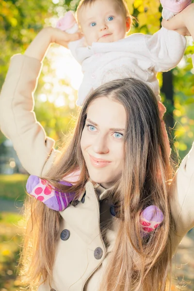 Hermosa madre con su bebé al aire libre en el parque de otoño —  Fotos de Stock