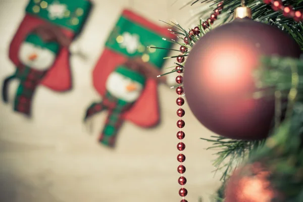 Bola vermelha decorada na árvore de Natal com meias no fundo — Fotografia de Stock