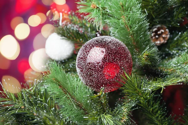 Decorated red ball on Christmas tree with bokeh at background — Stock fotografie