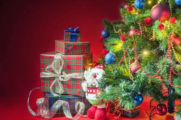 Decorated christmas tree with gift boxes and Santa Claus toy — Stock fotografie
