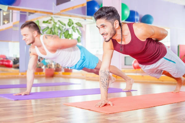 Dos jóvenes hombres multirraciales haciendo flexiones en interiores —  Fotos de Stock