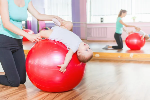 Matka z happy baby robienie ćwiczeń z piłki gimnastyczne — Zdjęcie stockowe