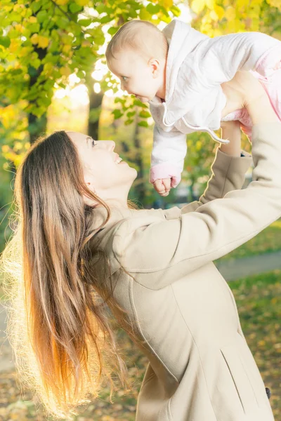 Vackra mamma med hennes baby flicka utomhus på hösten park — Stockfoto
