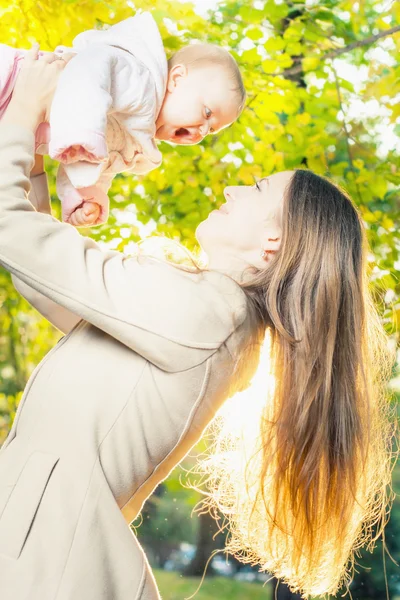 Happy mother with her baby girl outdoor at autumn park — 스톡 사진