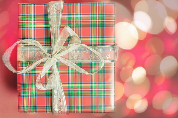 Caja de regalo de Navidad en fondo rojo con hermosa luz bokeh —  Fotos de Stock