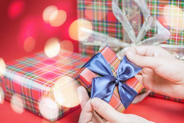 Caja de regalo de Navidad en fondo rojo con luces mágicas estrella —  Fotos de Stock