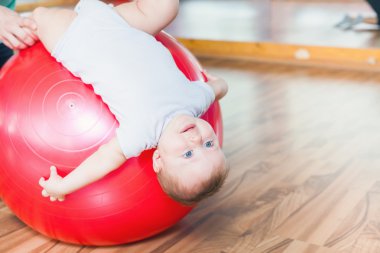 Jimnastik topu ile egzersizleri yapıyor mutlu bebek ile anne