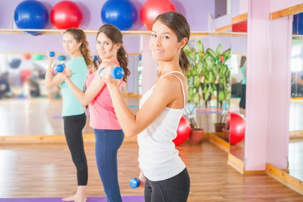 Vackra kvinnor gör fitness motion med vikt i händerna — Stockfoto