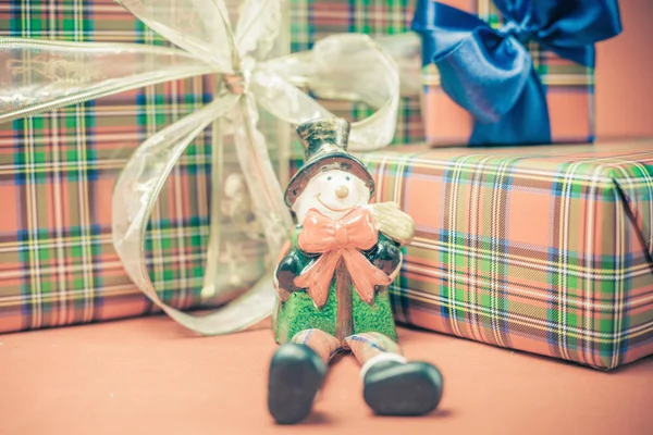 Caixa de presente de Natal com boneco de neve brinquedo no fundo vermelho — Fotografia de Stock