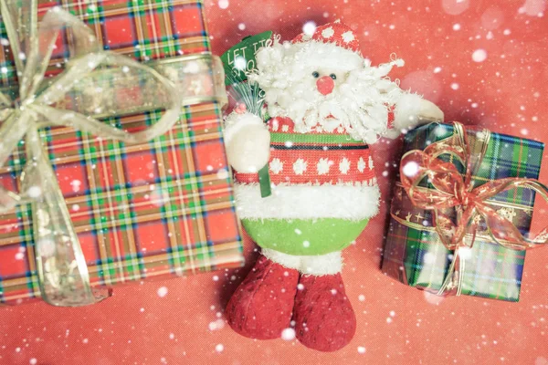 Caixa de presente de Natal com brinquedo Papai Noel no fundo vermelho — Fotografia de Stock