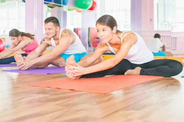 Los jóvenes llevan un estilo de vida saludable, hacen ejercicio en la sala de fitness —  Fotos de Stock