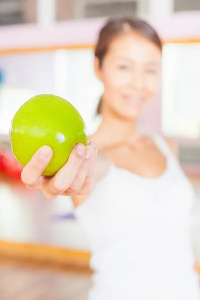 Healthy lifestyle concept with beautiful asian woman holding green apple — Stockfoto