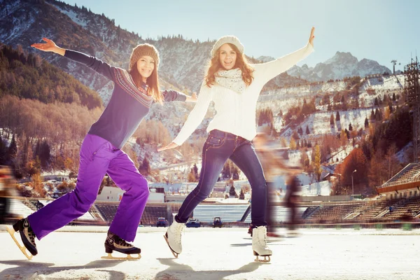 Grupo divertido adolescentes niñas patinaje sobre hielo al aire libre en pista de hielo —  Fotos de Stock