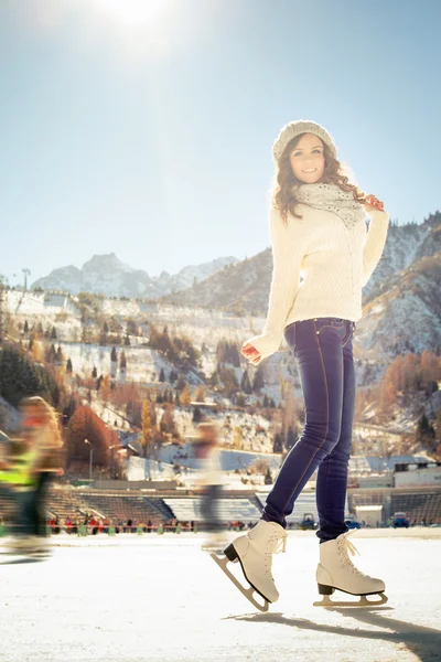 Chica bonita patinaje sobre hielo al aire libre en pista de hielo —  Fotos de Stock